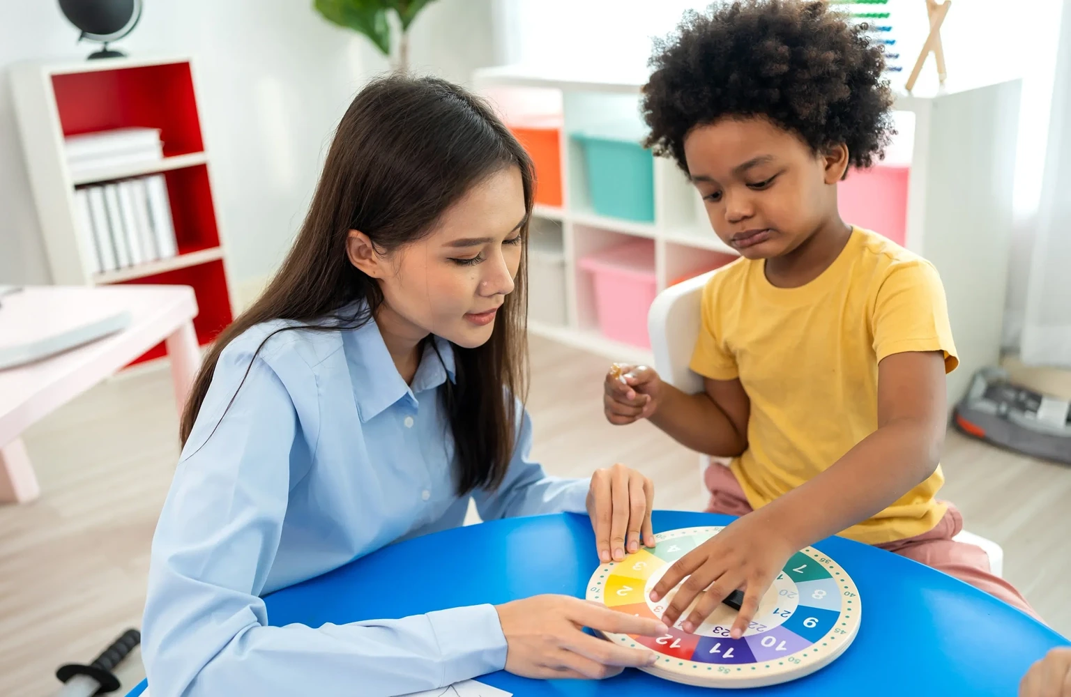 Therapist providing individualized Life ABA therapy to a young child with colorful blocks