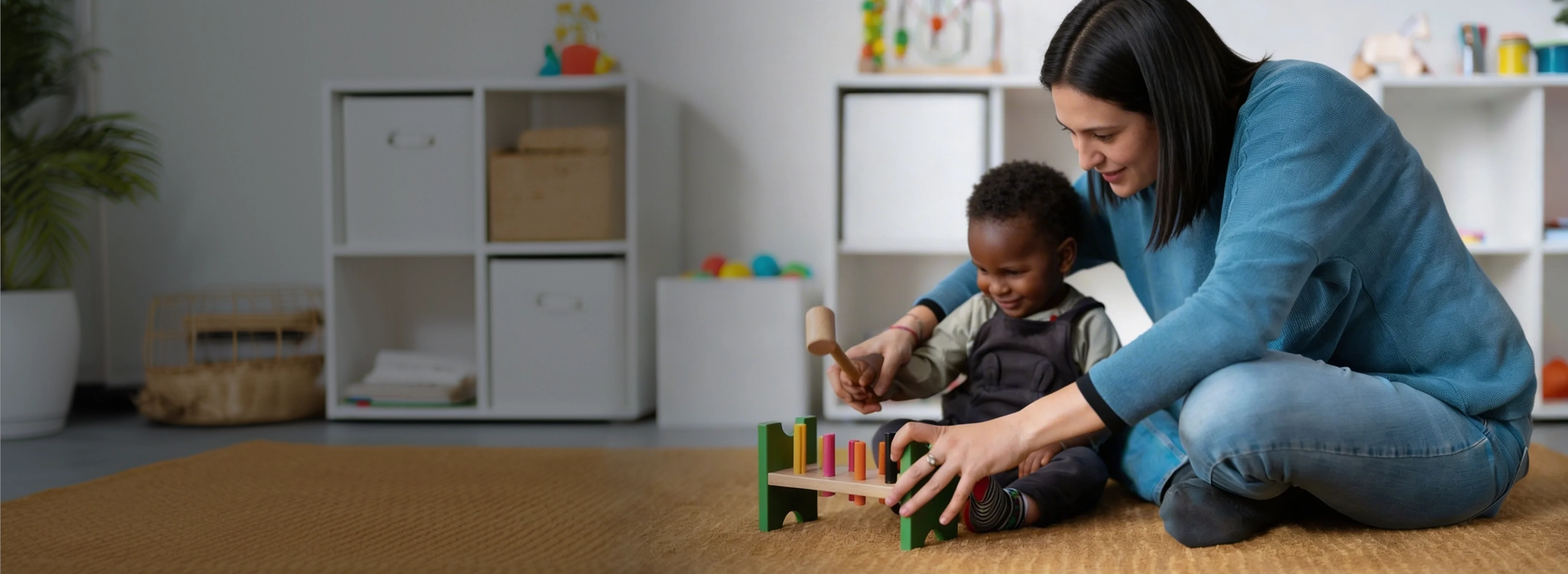 ABA therapist providing in-home therapy to a young child using educational play tools.