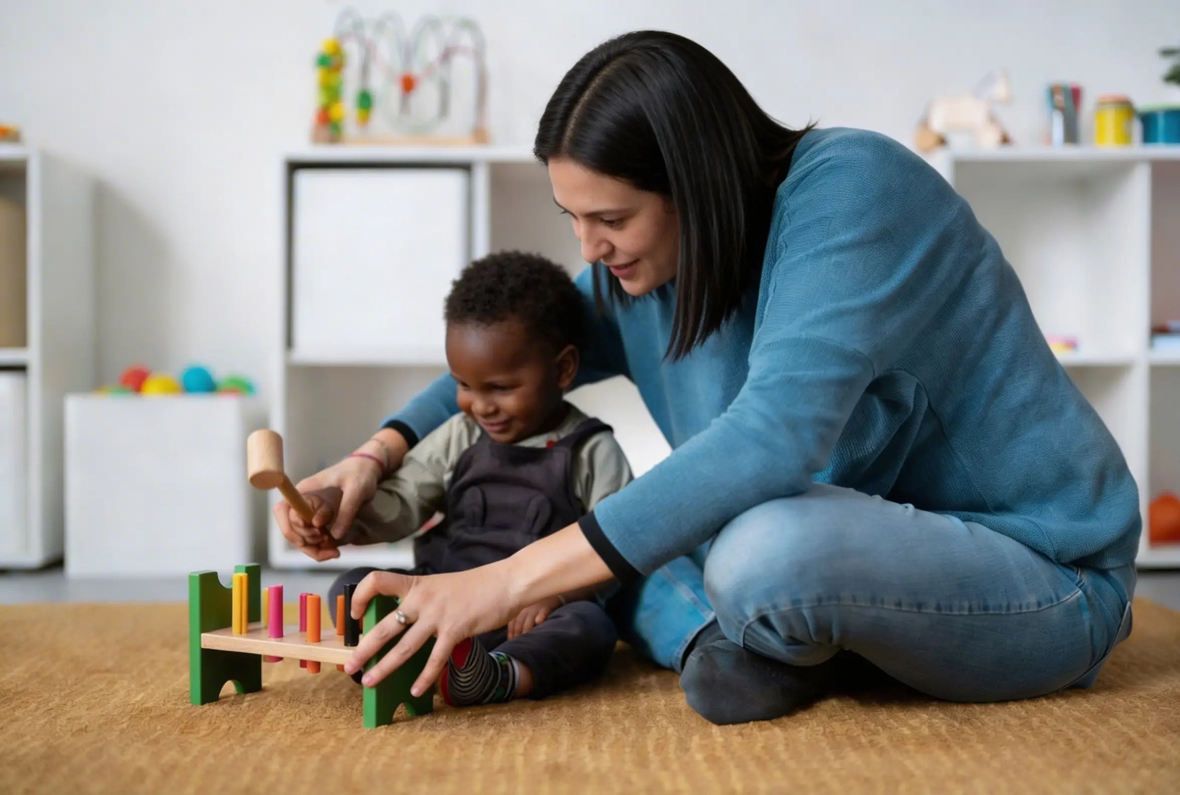 Direct 1:1 ABA therapy session with a trained Behavior Technician and child building with wooden toys.